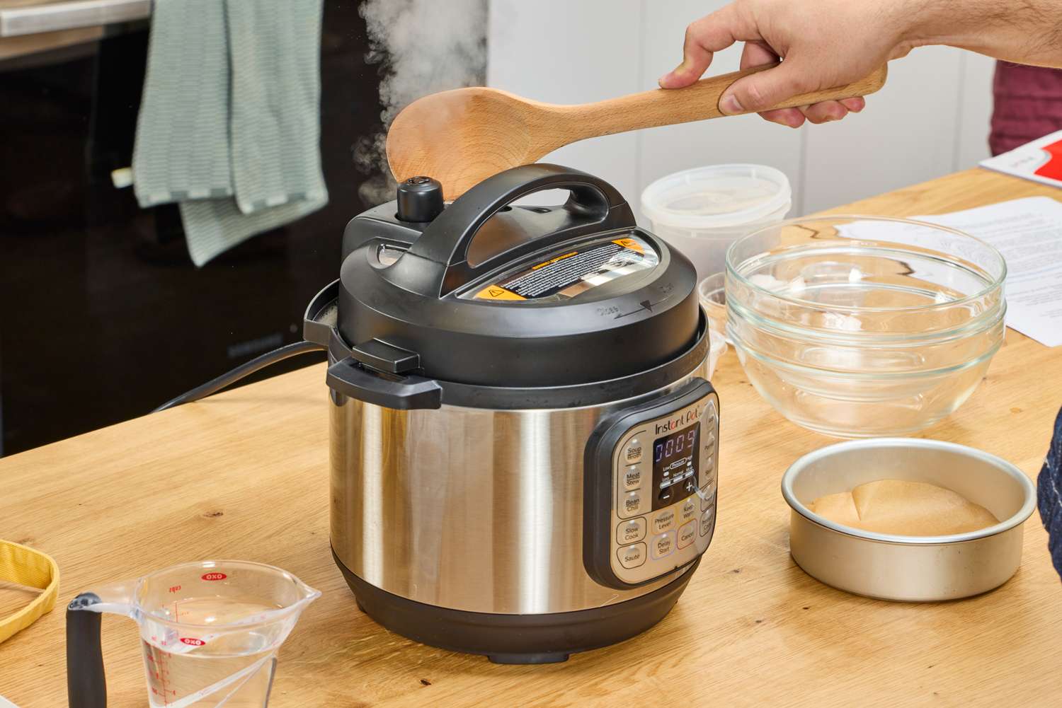A person releases pressure from the Instant Pot Duo Mini 3-Quart Multi-Use Pressure Cooker