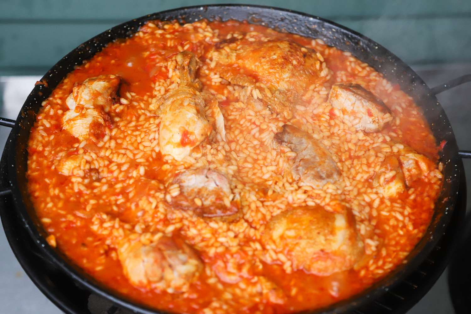 cooking paella in a paella pan on a grill