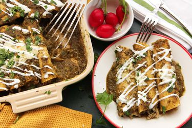 A serving of chicken enchilada, next to the baking dish where it's taken from. 