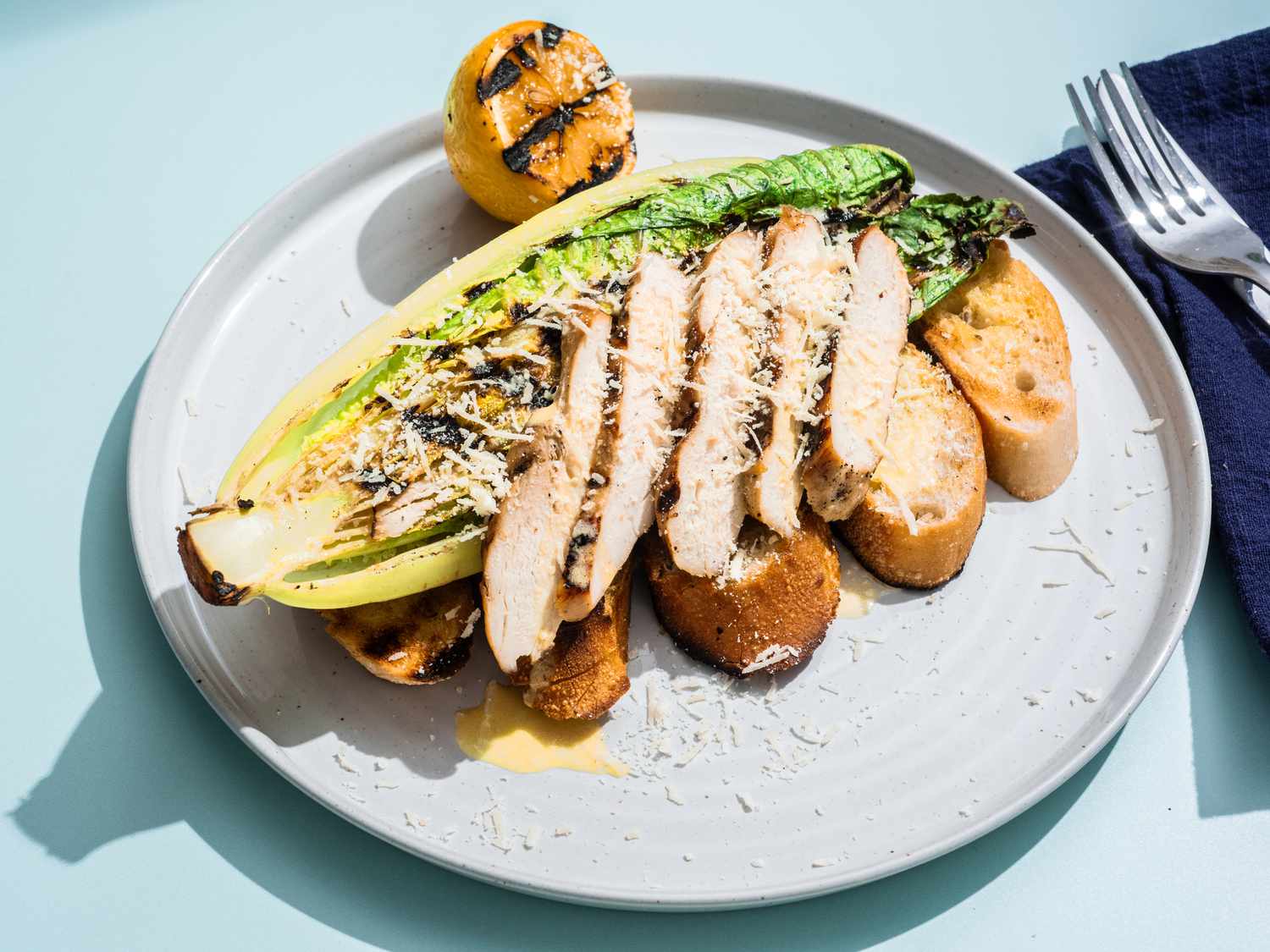 Grilled chicken caesar salad on a plate.