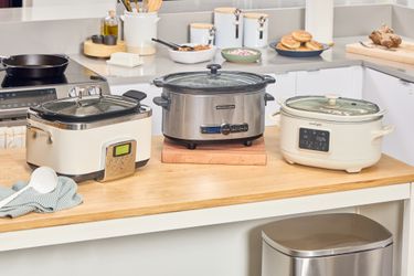 Three slow cookers on a kitchen counter