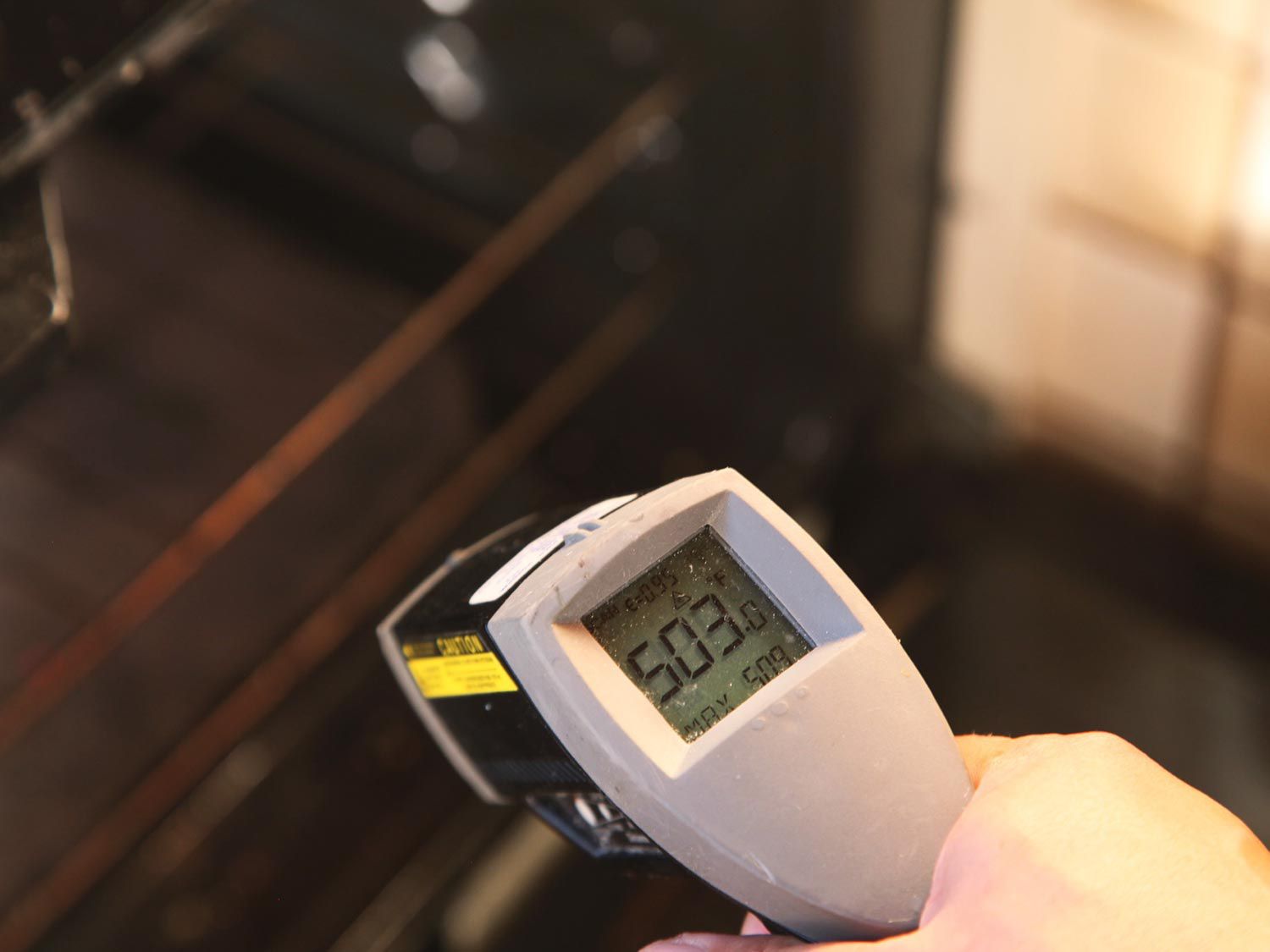 Taking the temperature of a baking steel with an infared thermometer