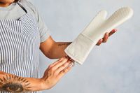 a person putting their hand into the oxo oven mitt