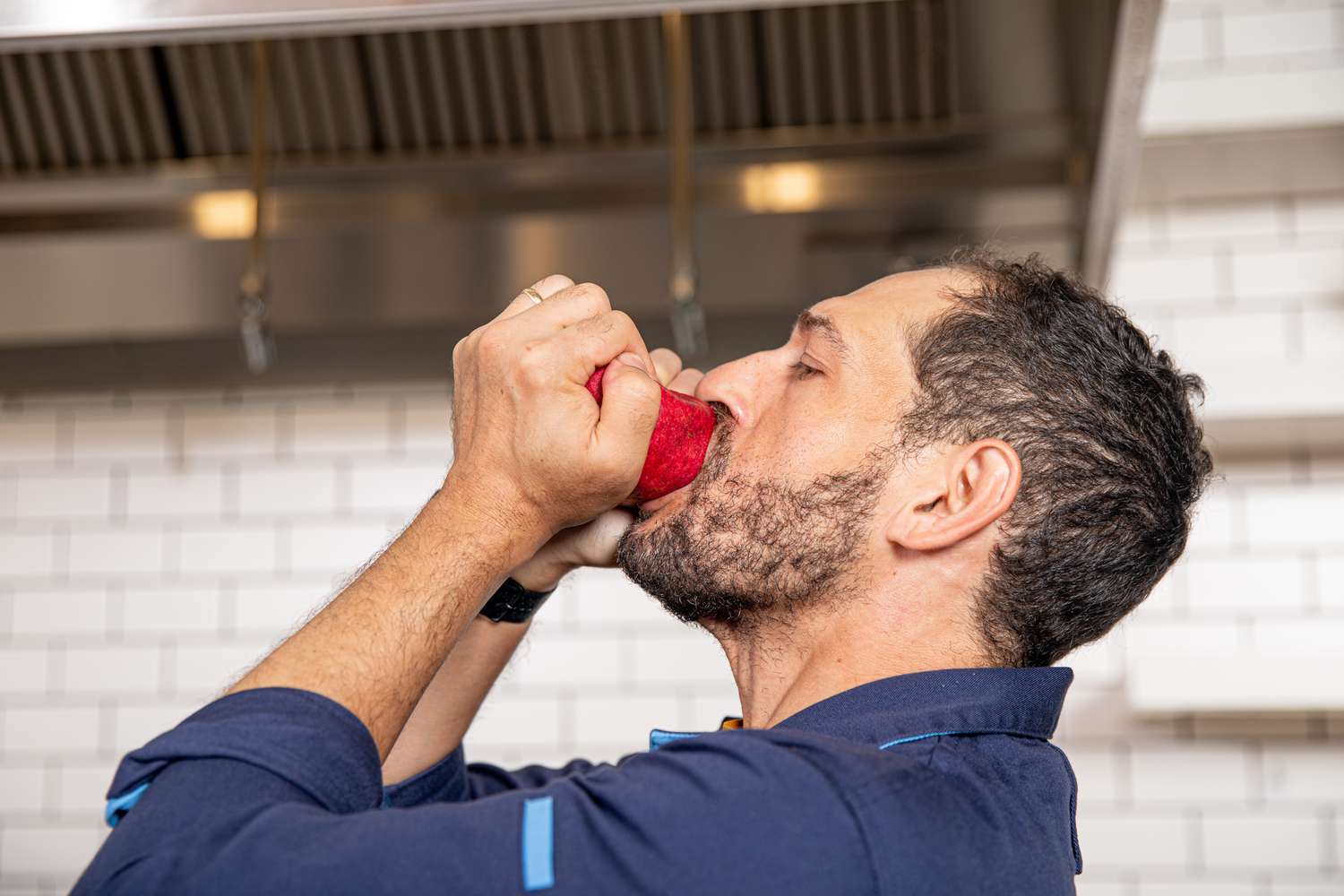 Side view of Daniel squeezing a pomegranate 