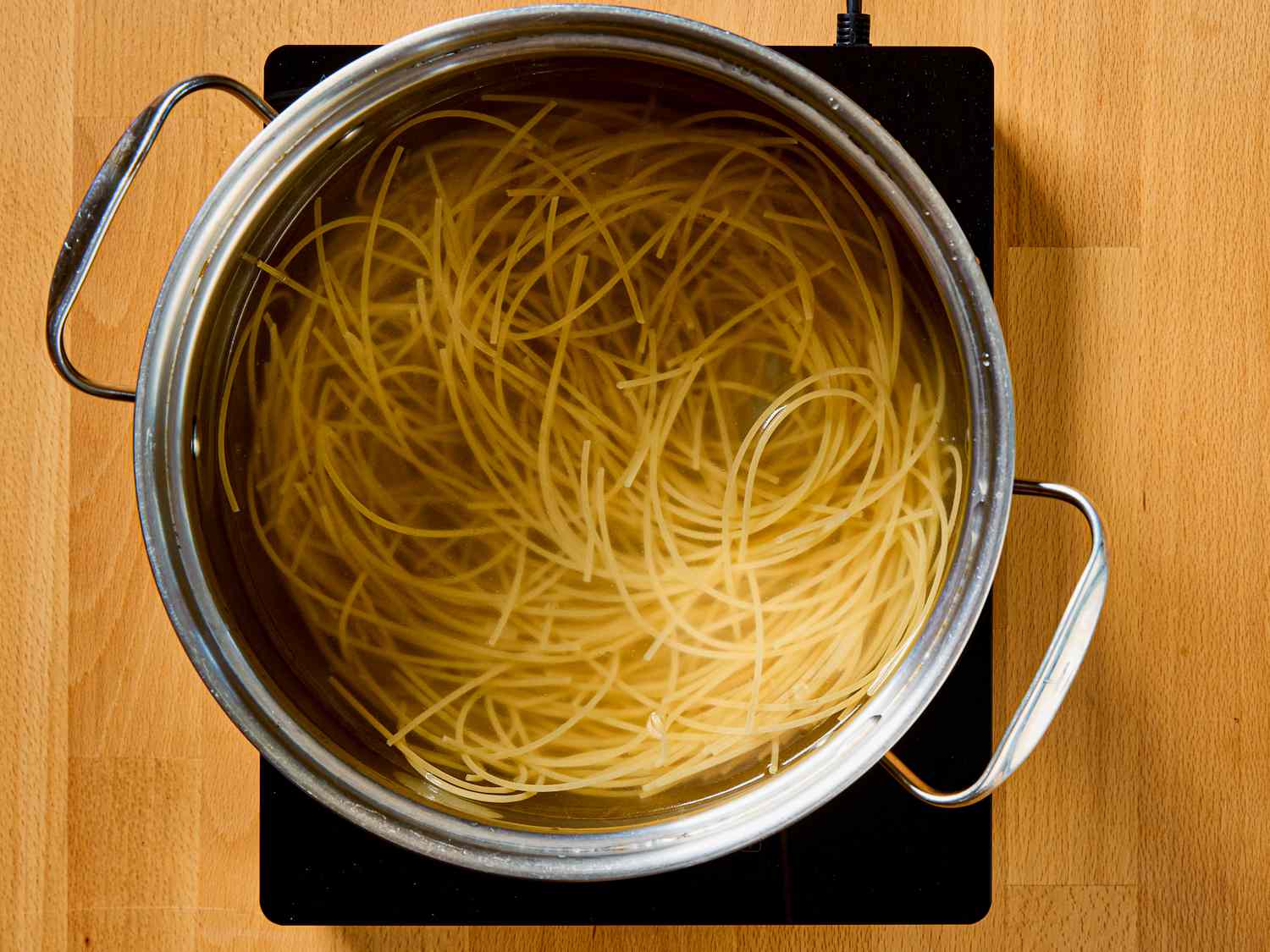 Pot of spaghetti boiling on a stovetop