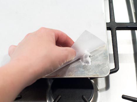 Anchoring parchment paper on a baking tray with meringue. 