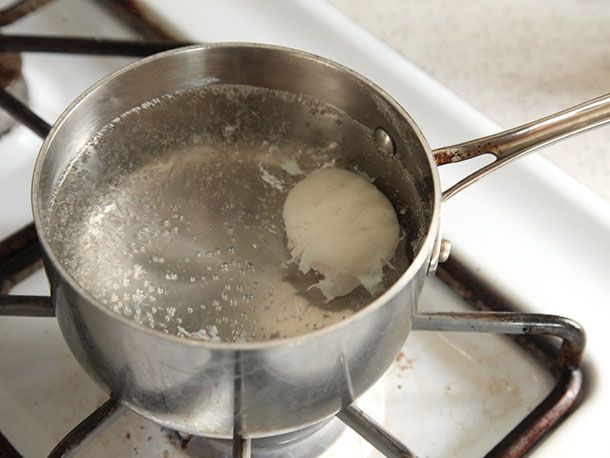 Sous vide poached egg firming up in pot of simmering water