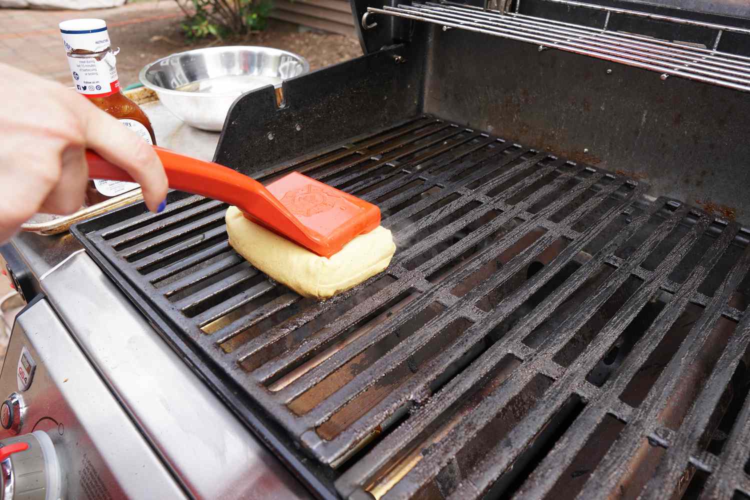 A closeup look at an aramid fiber-wrapped grill brush cleaning a grill grate