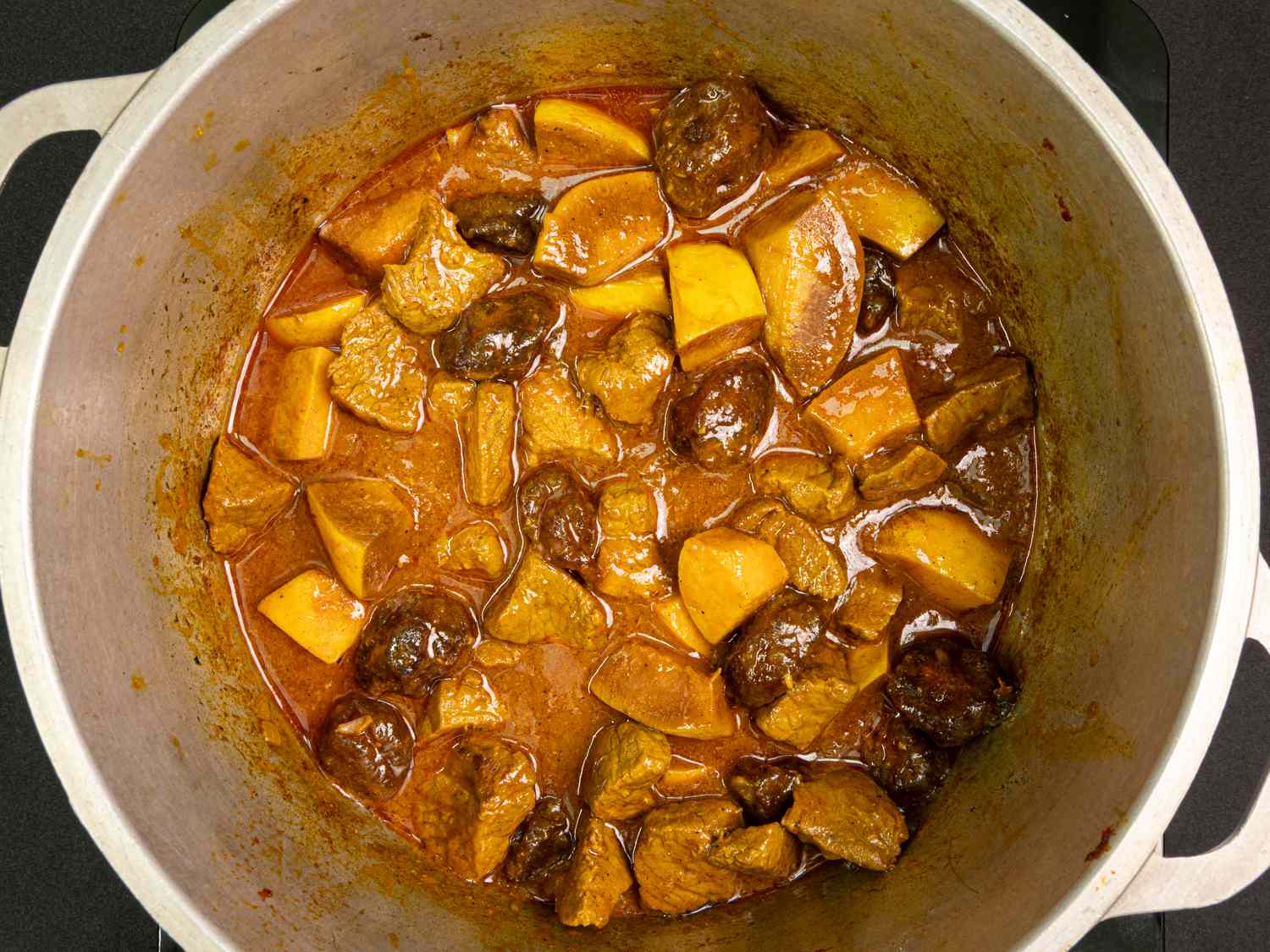 A pot of khoreshebeh a Persian stew with pieces of lamb quince and prunes
