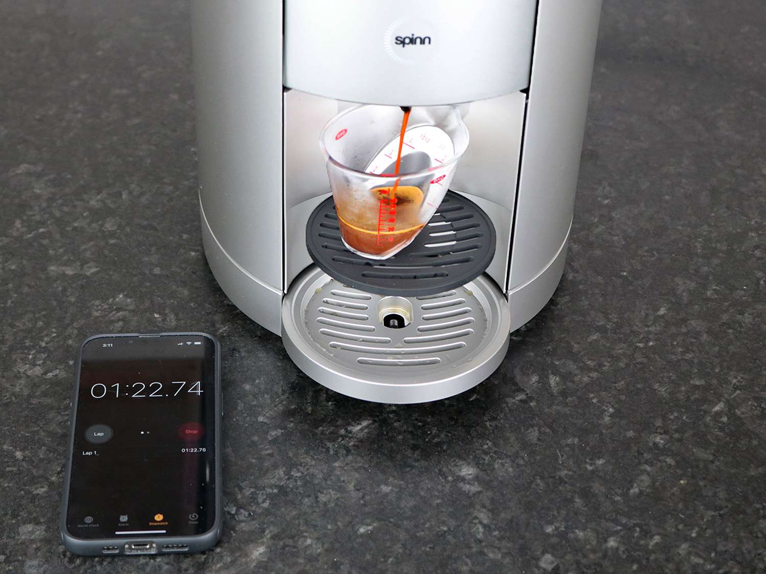 The spinn brewer brewing espresso into a small angled measuring cup