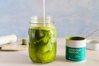 A glass of Rishi Tea Everyday Matcha next to the container