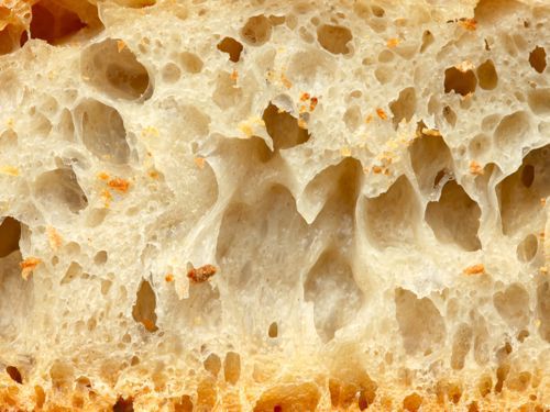 Closeup of cross-section of well-fermented bread filled with holes