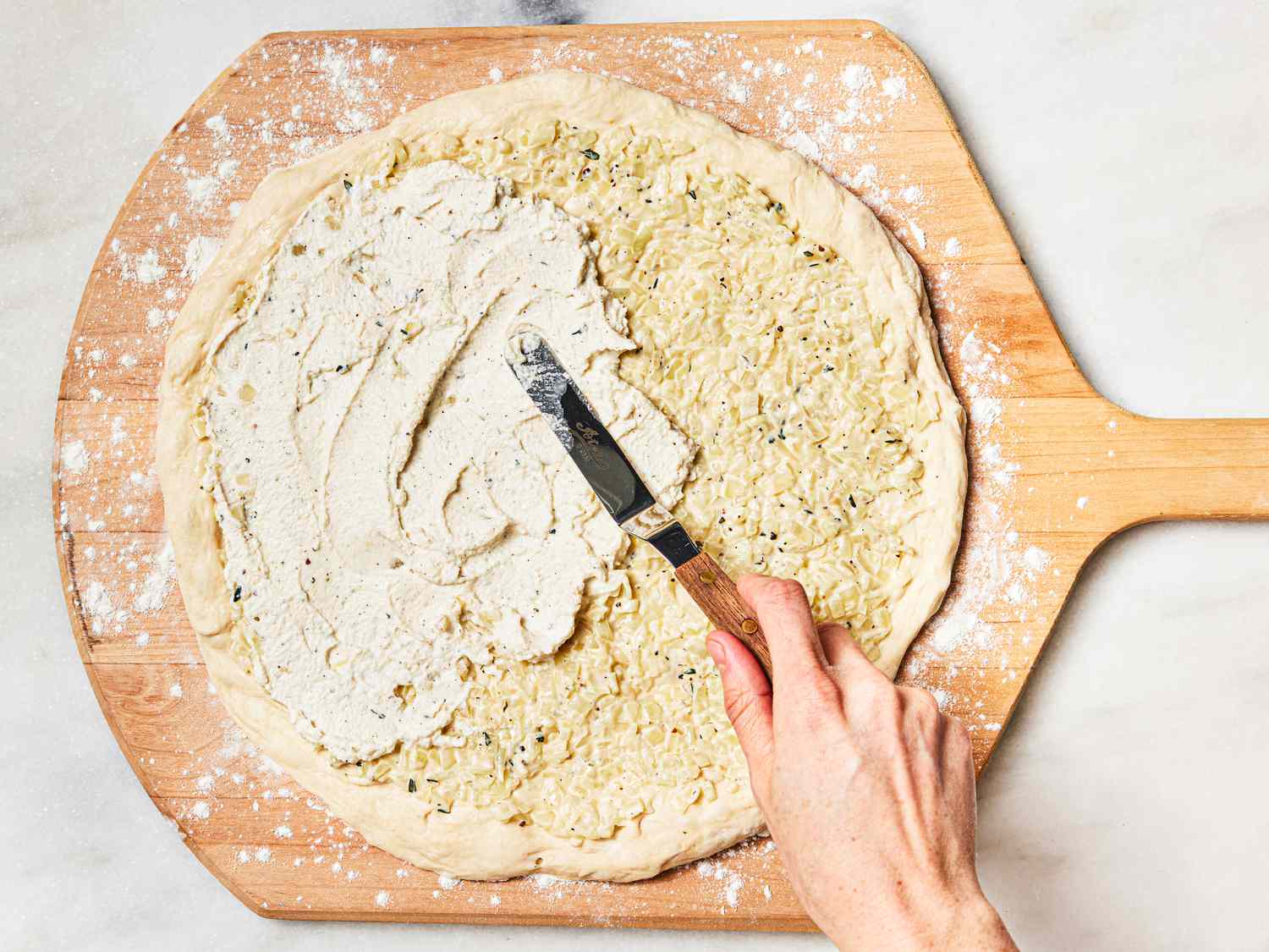 Spreading cheese on pizza dough