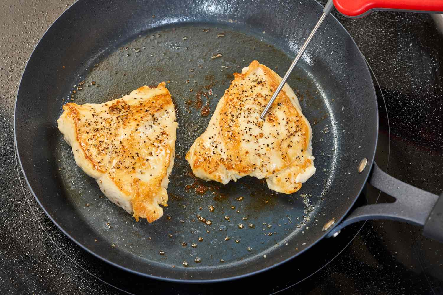 A person takes the temperature of chicken cooked in the OXO Obsidian 10 Inch Pre-Seasoned Carbon Steel Frying Pan