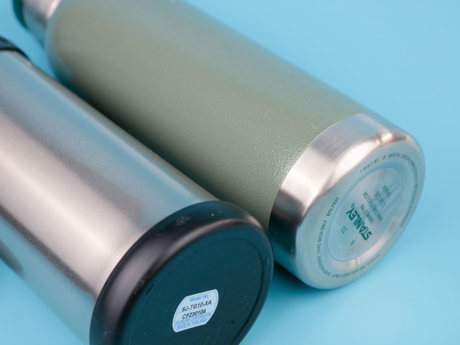 Two thermoses side-by-side on a blue surface