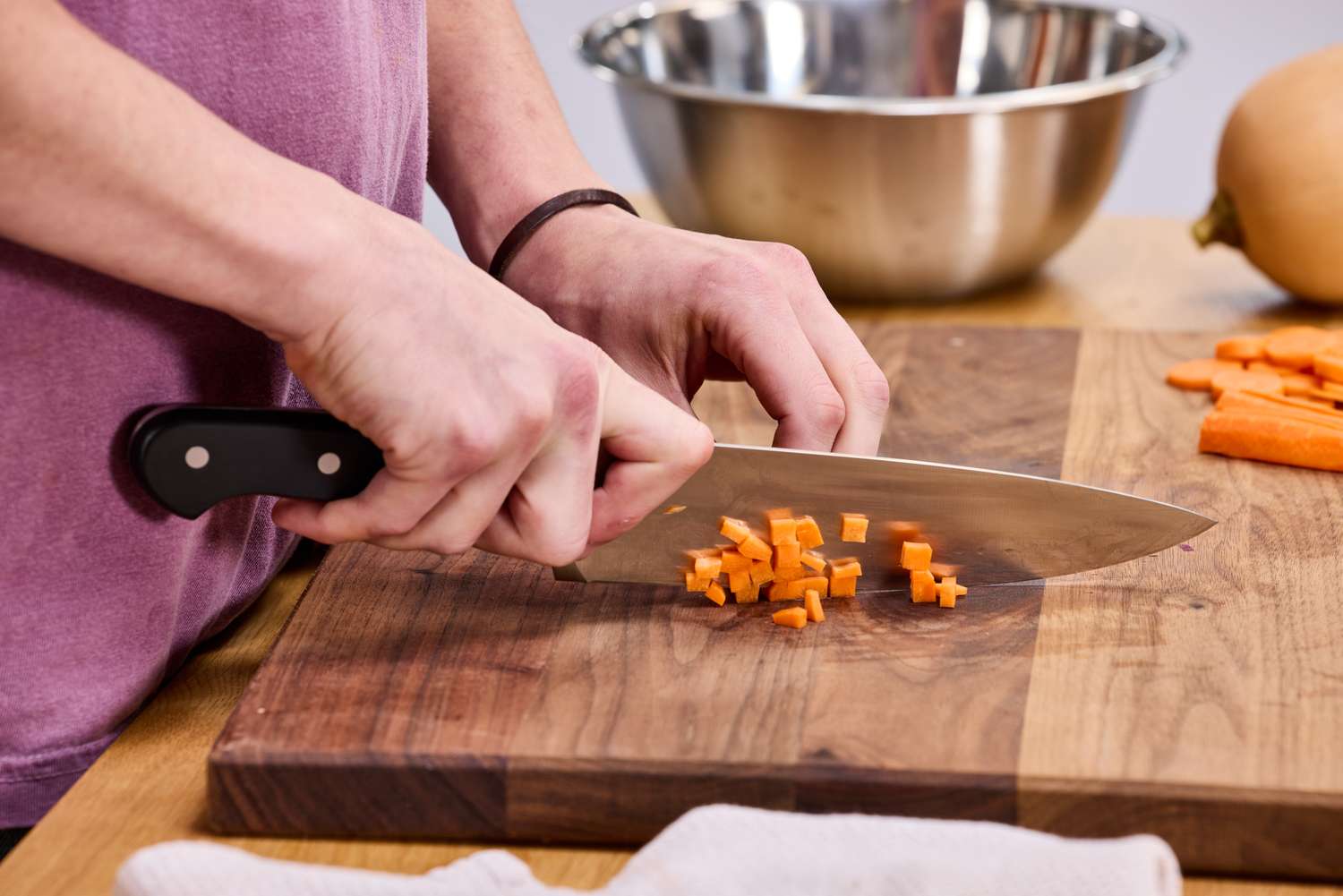 A person cuts carrots using the Wüsthof Classic 8-Inch Chef's Knife