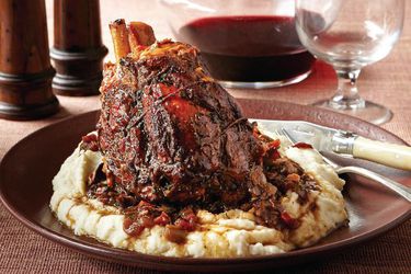 A serving of stinco (braised and roasted pork shanks), served atop mashed potatoes.