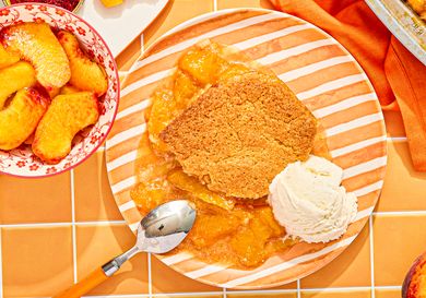 Peach cobbler with ice cream on a striped plate