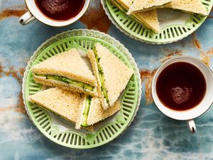 Overhead view of cucumber sandwiches on a green plate