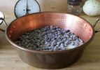 A copper pot filled with blueberries and uncooked sugar.