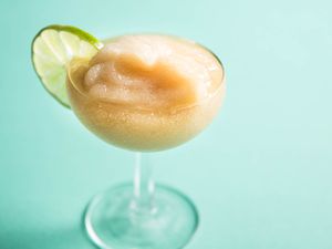 Frozen daiquiri in a coupe glass garnished with a lime wheel.