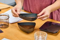 A person examines coffee beans ground in the Breville The Smart Grinder Pro