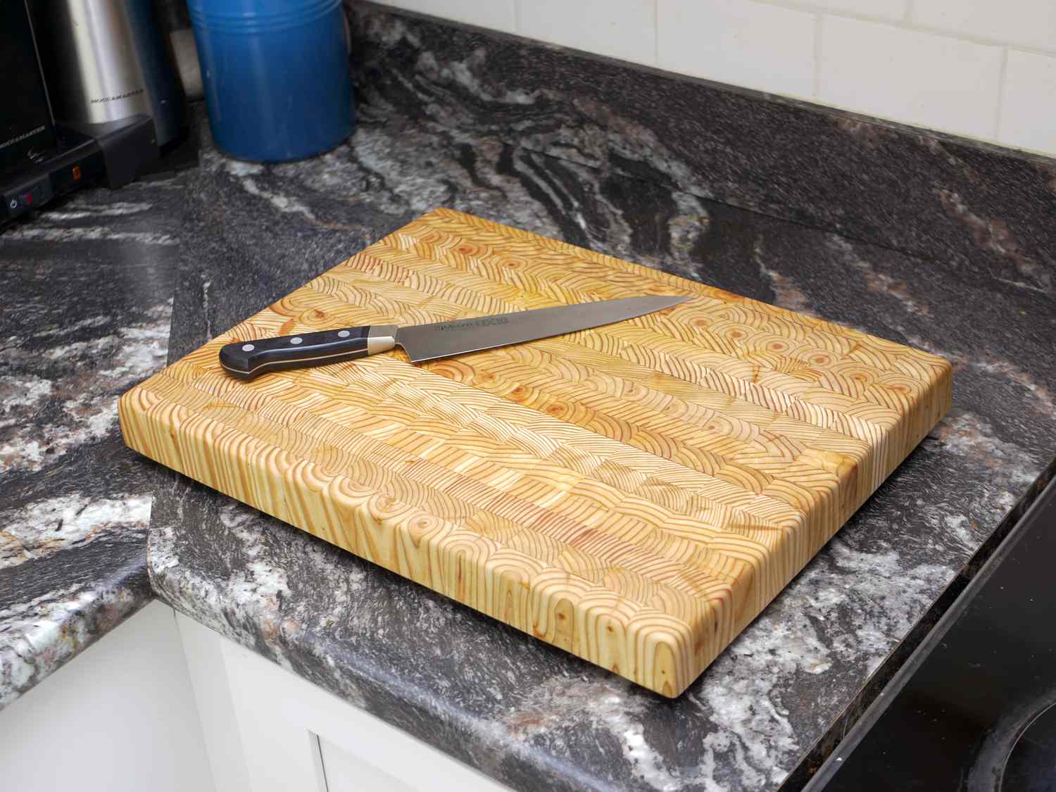 the larch wood board on a countertop with a chef's knife
