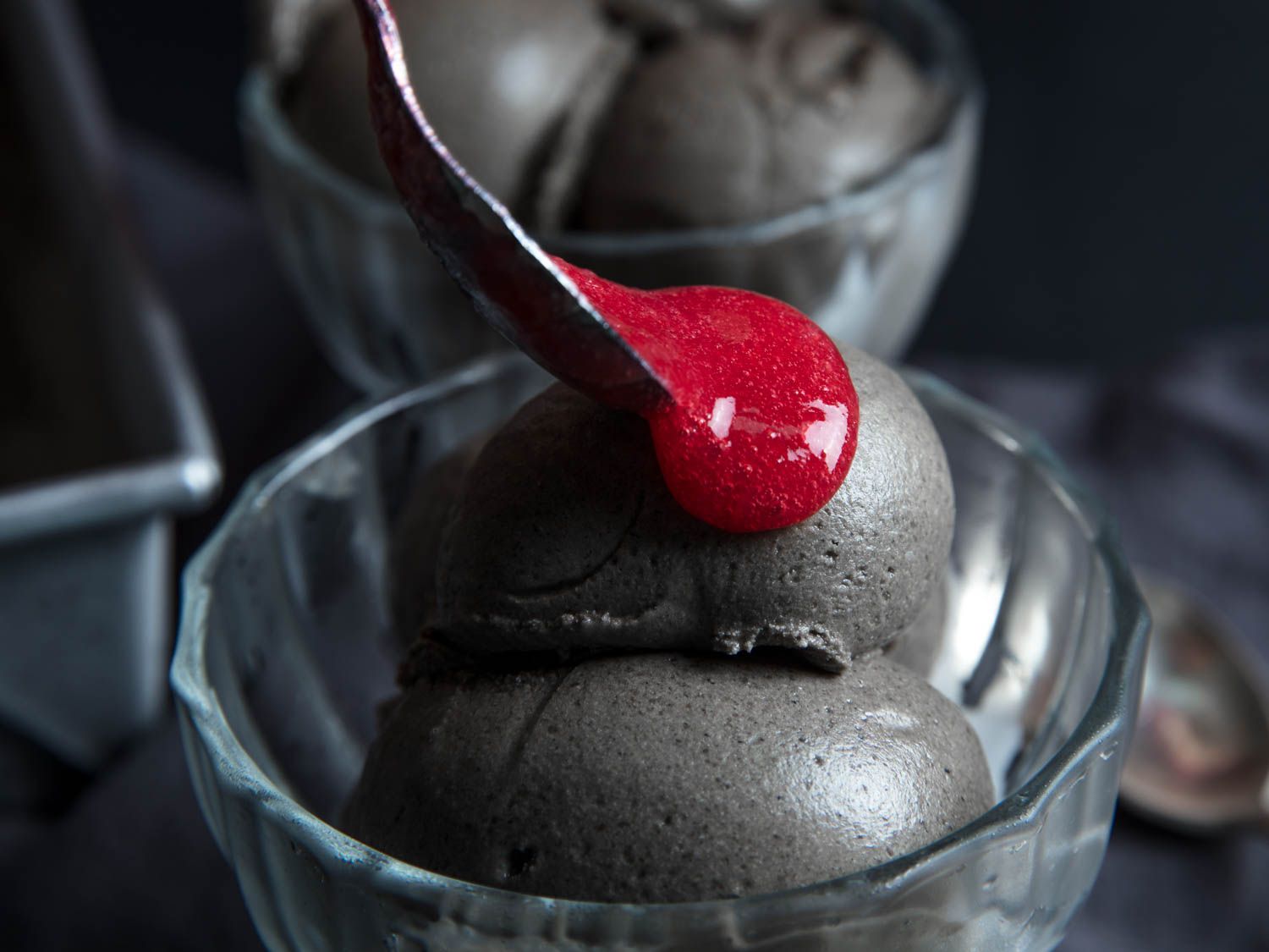 Topping black sesame ice cream with raspberry puree.