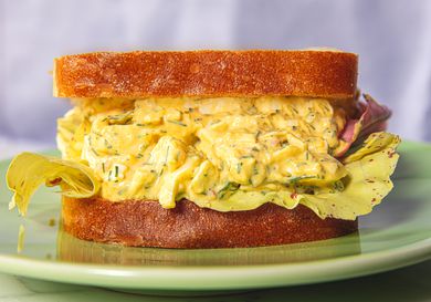 Egg salad sandwich on bread, served on a plate