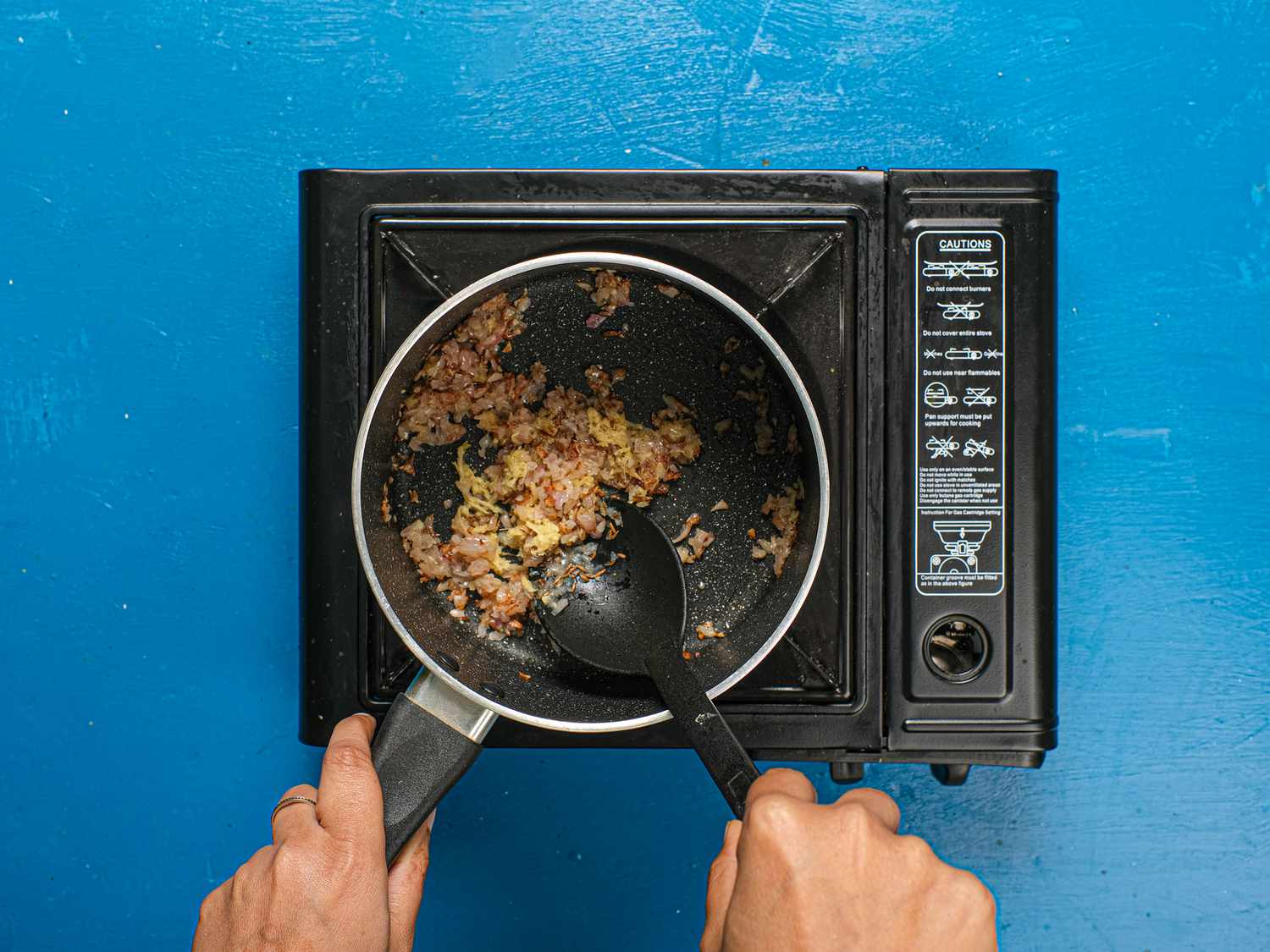 Sauteeing ginger into onions in pot