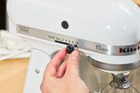 A person adjusts the speed on the KitchenAid Classic Plus Series 4.5 Quart Tilt-Head Stand Mixer