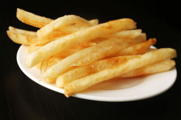 Perfect thin and crispy French fries, served on a small white saucer.
