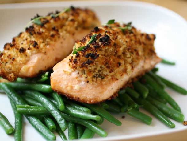 Closeup of Easy Crunchy Mustard-Baked Salmon, served on a bed of blanched green beans.
