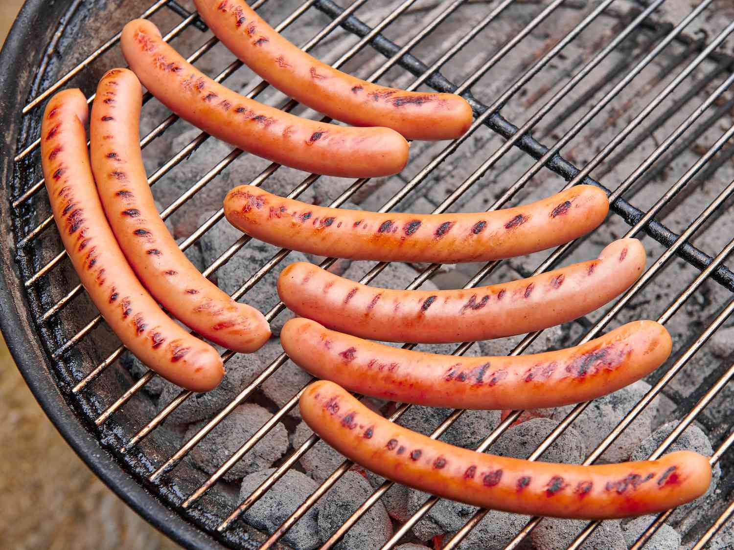 Overhead view of hot dogs on grill