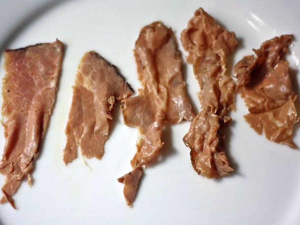 Five slices of roast beef that have been dipped in broth at incrementally higher temperatures. The three slices on the right have been cooked at higher temperatures and look progressively contracted or "crumpled."