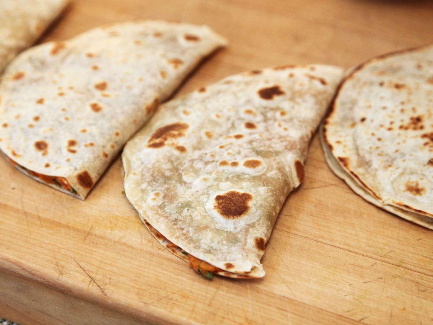 Quesadilla filled with mashed sweet potatoes on a cutting board. 