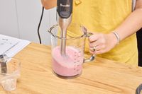 A person makes a smoothie using the Breville Control Grip Immersion Blender