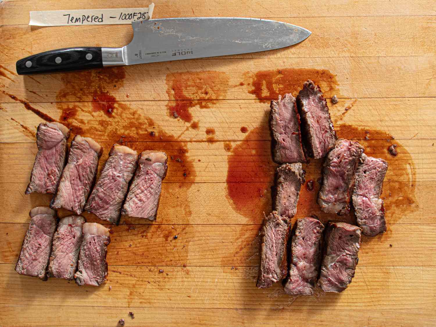 Pieces of cooked meat arranged on a cutting board beside a knife