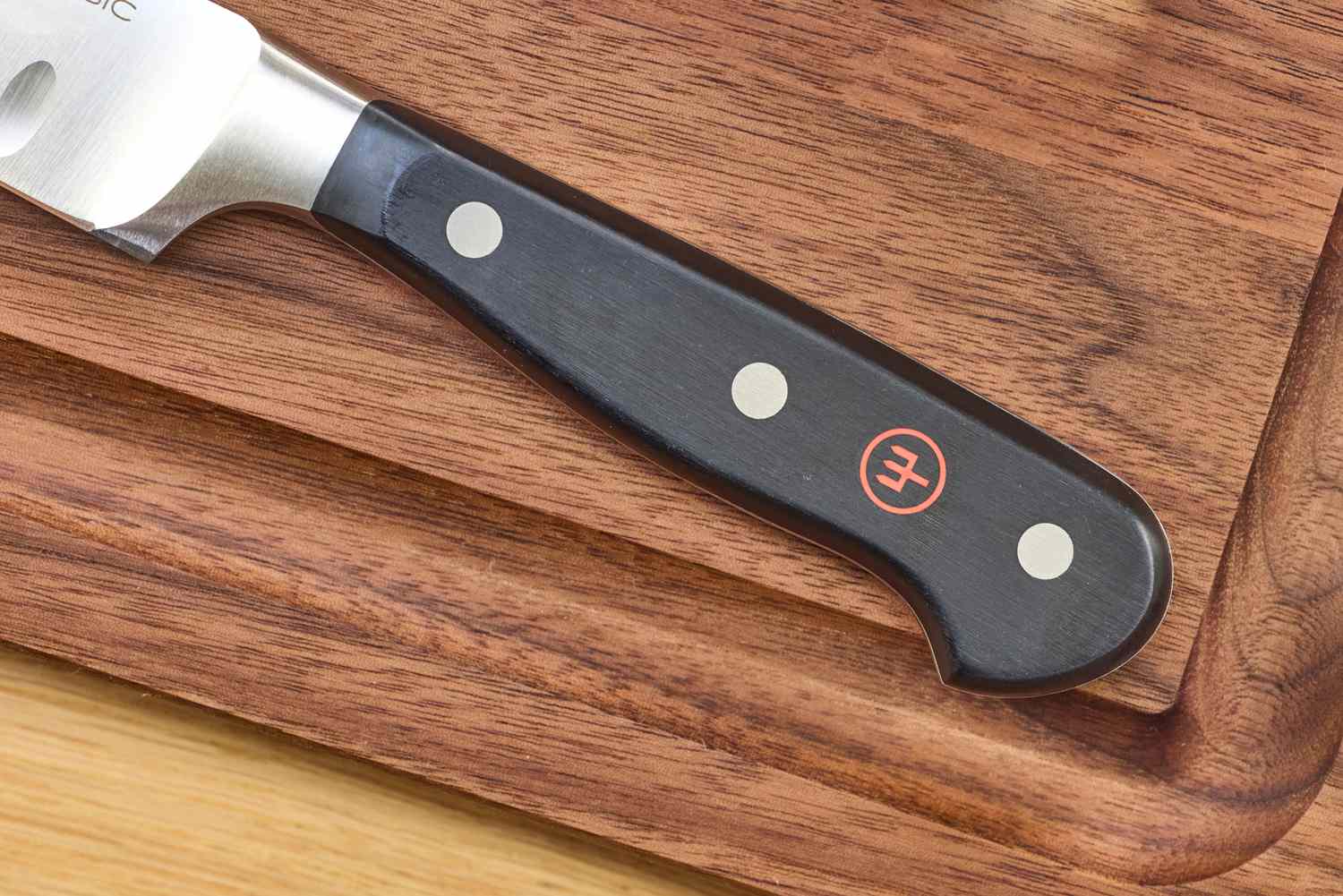 Closeup of a knife handle on a wooden cutting board
