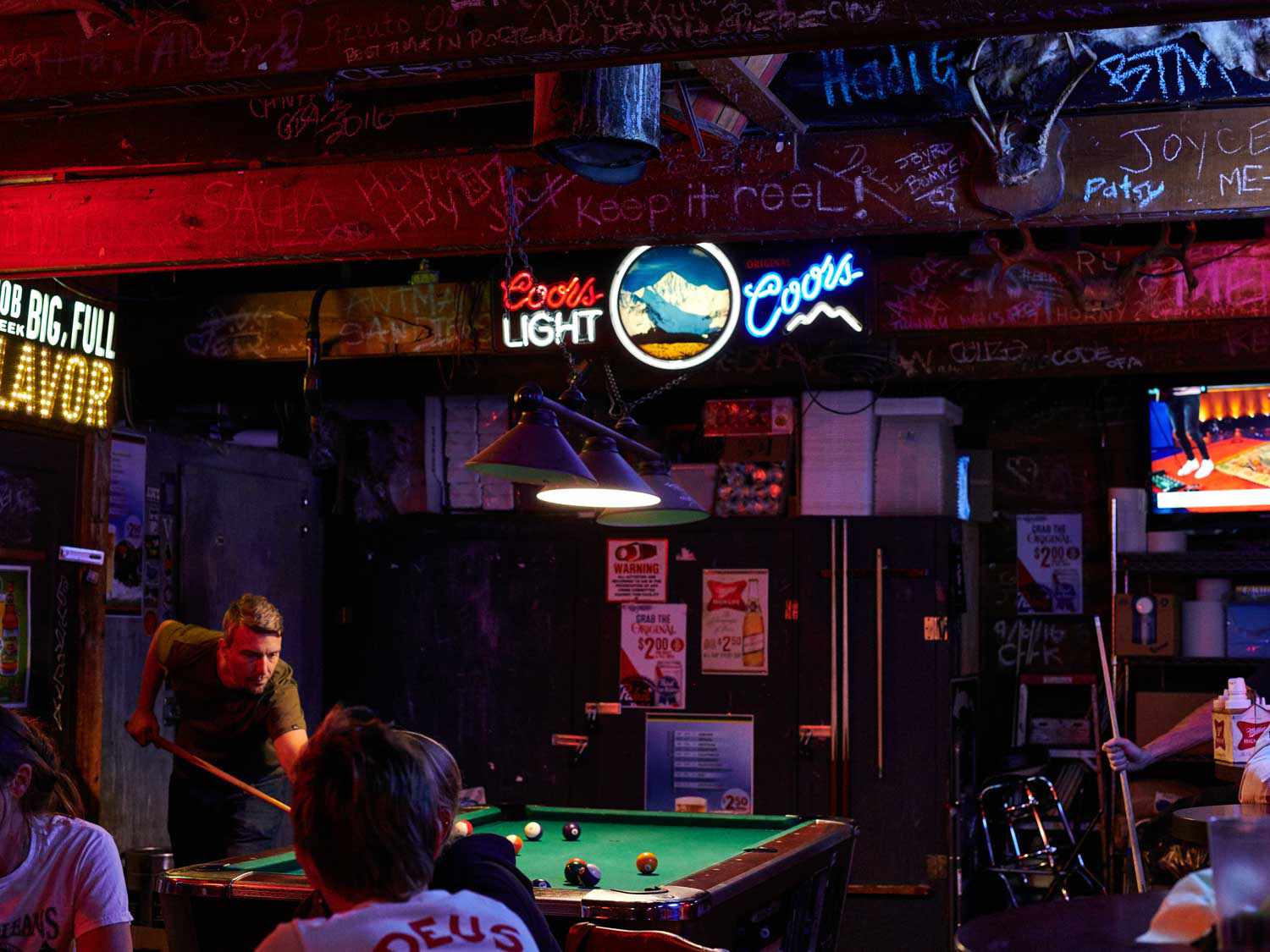 Billiards and neon signage inside Reel M Inn