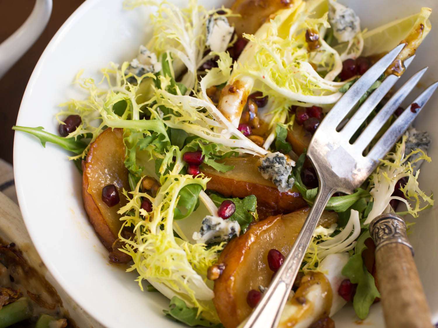 Roasted Pear Salad With Endive, Pomegranate, Blue Cheese, and Hazelnut Vinaigrette