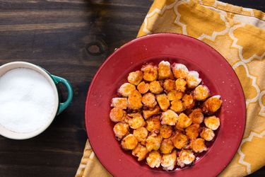 Overhead view of pulpo gallego served on a red plate.
