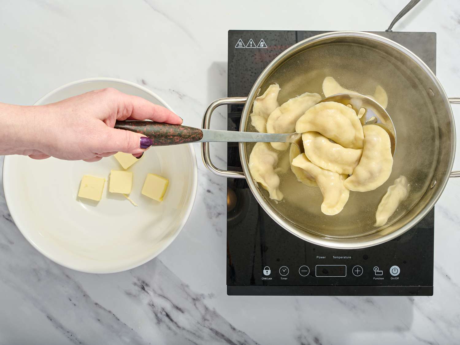 Placing dumplings in a bowl with slotted spoon. 