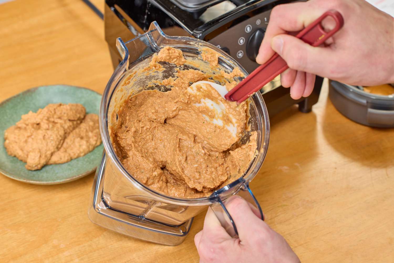 A person using a silicone spatula on items blended in the Vitamix Propel 510