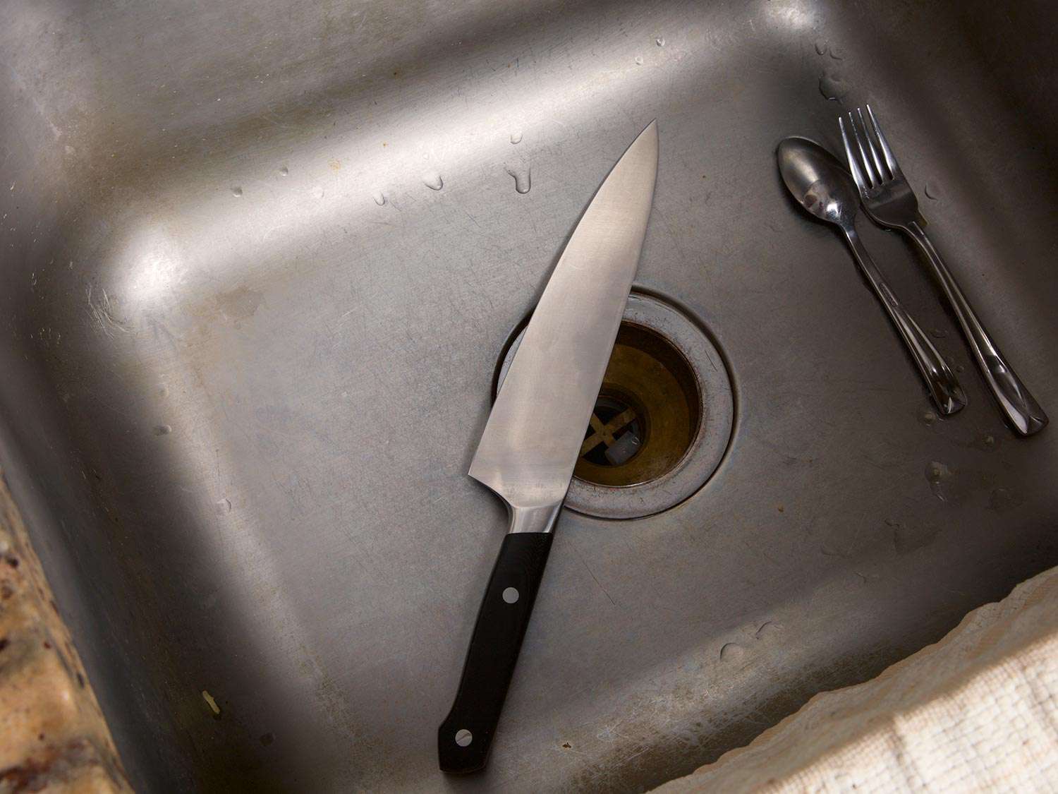 A knife sitting at the bottom of a sink