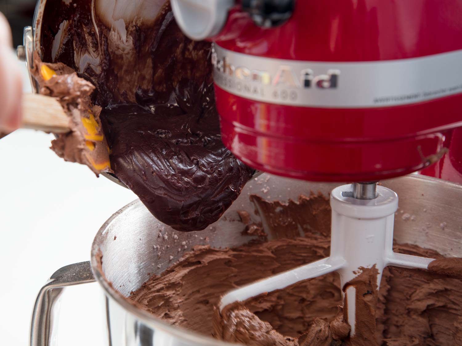 Adding the cooled ganache to the cocoa frosting.