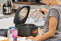A person pours water into the Zojirushi NW-QAC10 Induction Heating Rice Cooker & Warmer