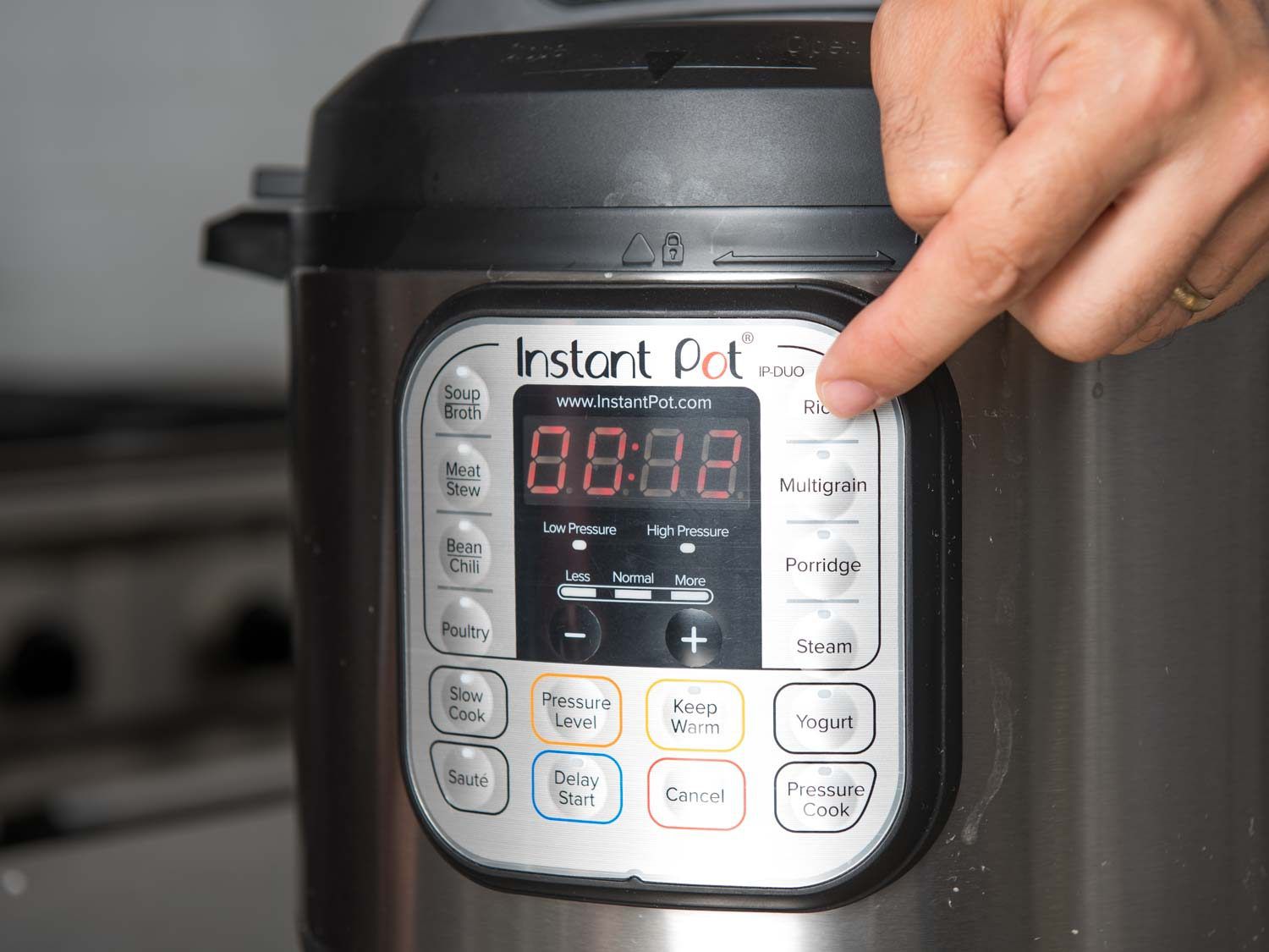 Person selecting rice function on Instant Pot multi-cooker.