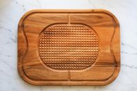 Lipper International Acacia Cutting Board with Grid Grip placed on floor