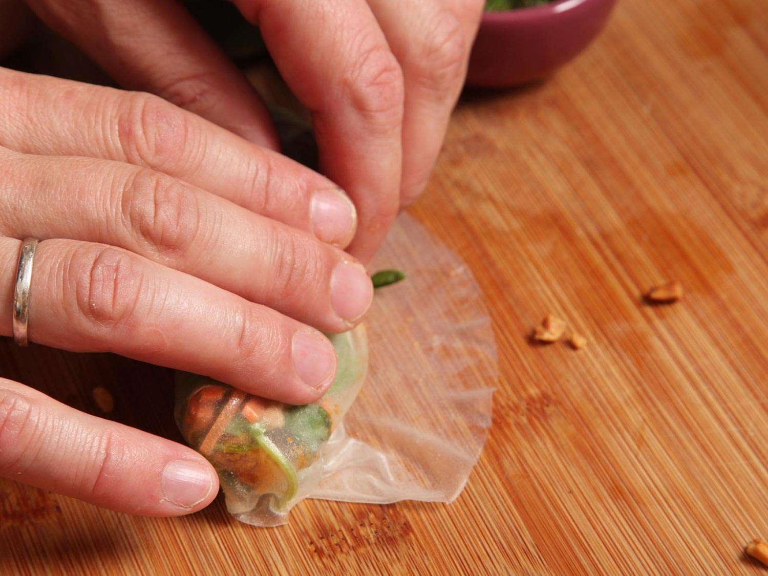 The author rolls up the rice paper wrapper into a tight bundle.